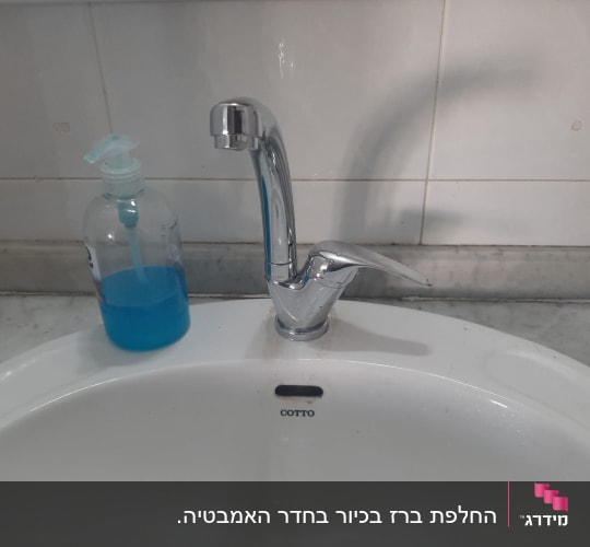 ברז כרום מותקן בכיור לבן עם סבון נוזלי כחול